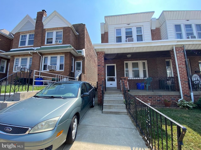 multi unit property featuring a porch and cooling unit