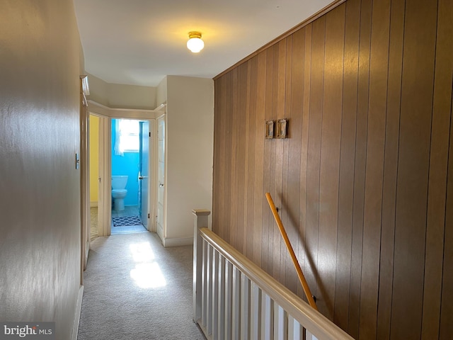 hallway with light carpet and wooden walls