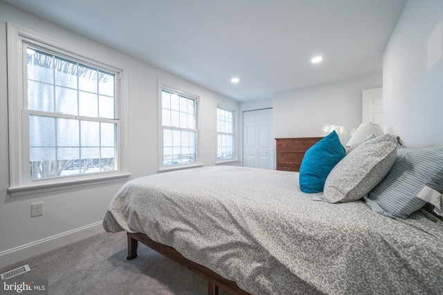 bedroom with multiple windows, a closet, and carpet floors