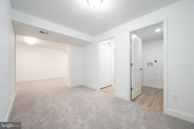 unfurnished room featuring light colored carpet