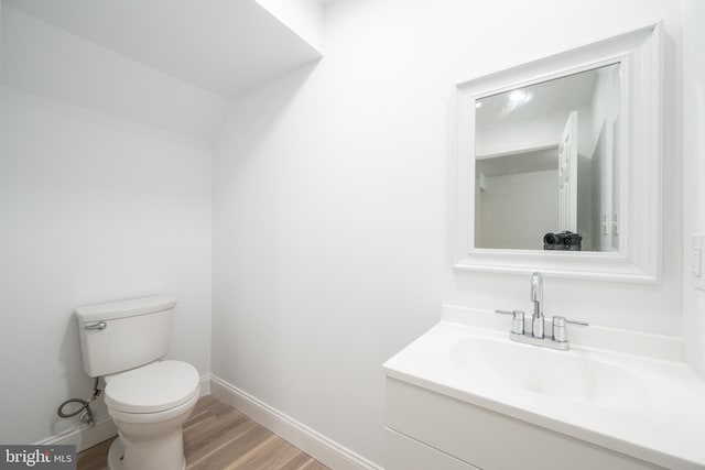 bathroom with hardwood / wood-style floors, vanity, and toilet