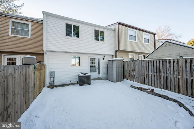 snow covered rear of property with central AC unit