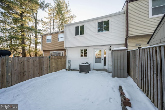 snow covered house featuring central AC