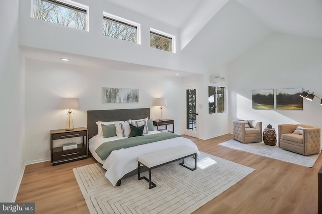 bedroom with a towering ceiling and light hardwood / wood-style flooring