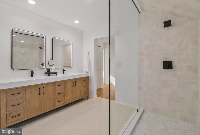 bathroom with tiled shower, vanity, and tile patterned floors