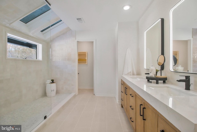 bathroom with tile patterned flooring, vanity, and walk in shower