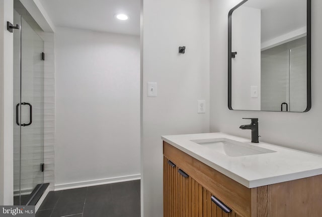 bathroom with tile patterned flooring, vanity, and walk in shower