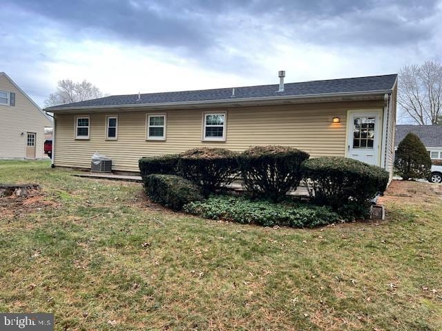 rear view of property with a yard and cooling unit