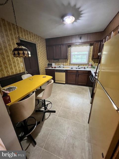 kitchen with dark brown cabinetry, stainless steel fridge, dishwasher, and pendant lighting