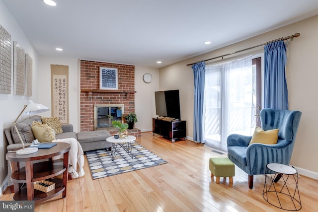 living room with a fireplace and light wood-type flooring