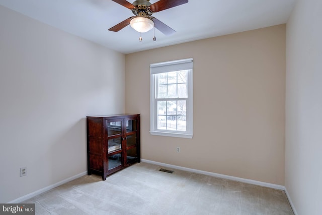 carpeted spare room featuring ceiling fan