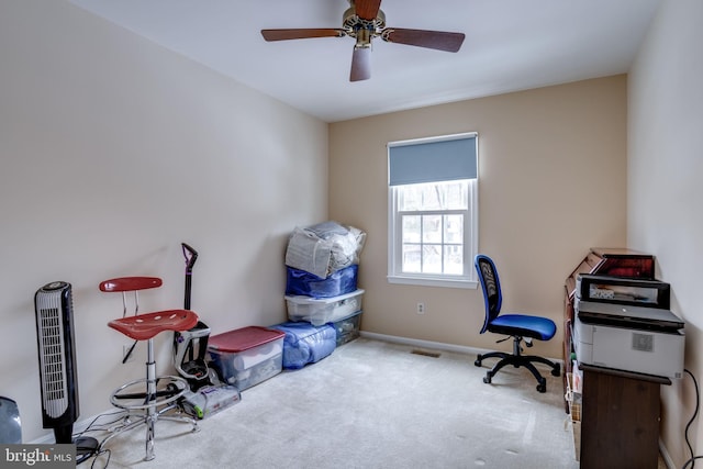 carpeted office space with ceiling fan