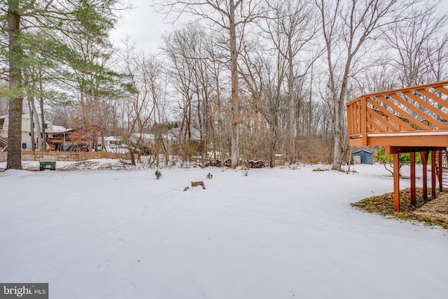 snowy yard featuring a wooden deck