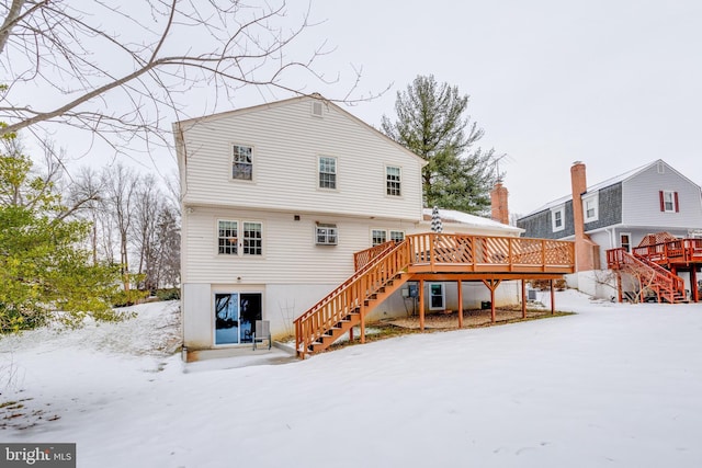 snow covered house with a deck