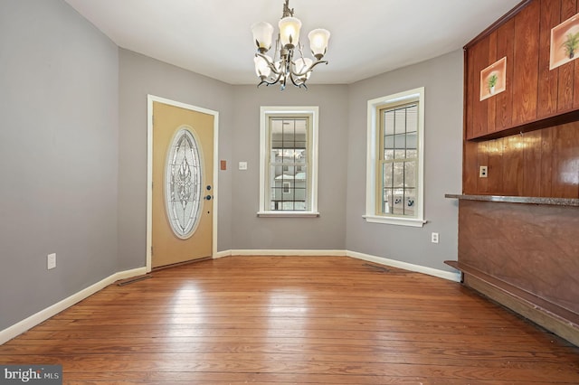 entrance foyer featuring hardwood / wood-style flooring and an inviting chandelier