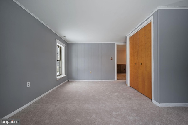 spare room featuring light carpet and crown molding