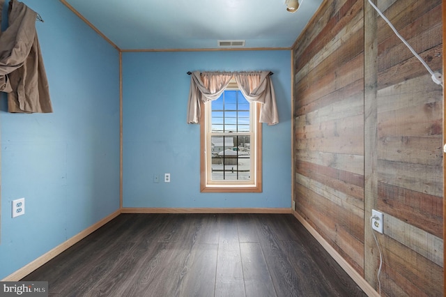 unfurnished room featuring wood walls and dark wood-type flooring