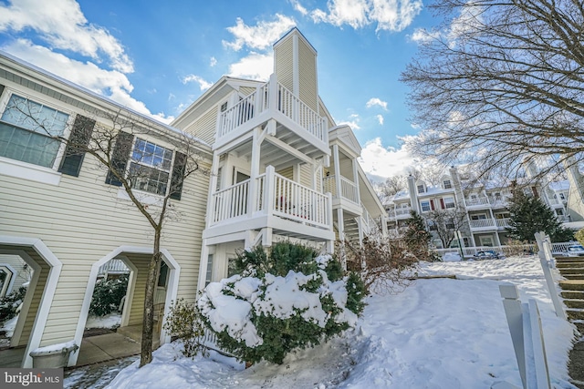 view of snowy exterior featuring a balcony