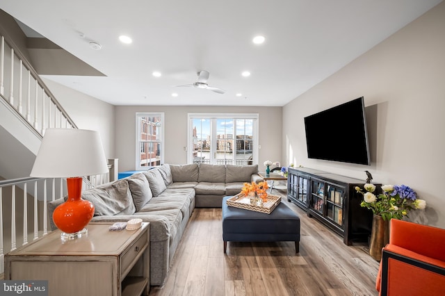 living room featuring ceiling fan and light hardwood / wood-style flooring