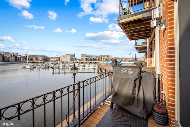 balcony with area for grilling and a water view