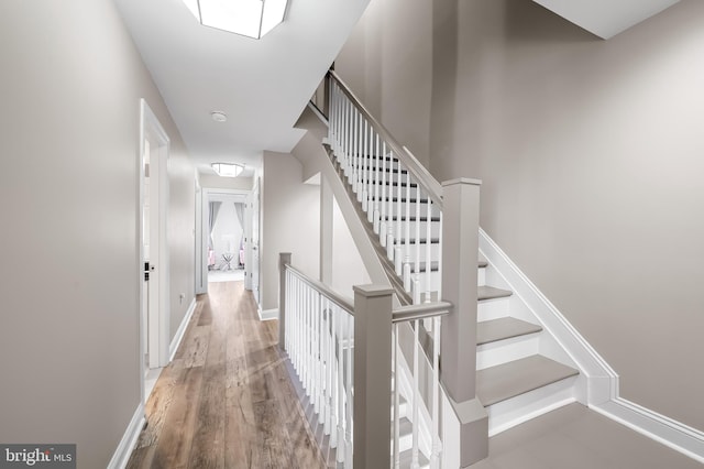 stairs featuring hardwood / wood-style floors