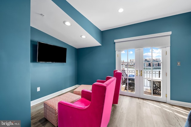 cinema featuring french doors, hardwood / wood-style floors, and vaulted ceiling