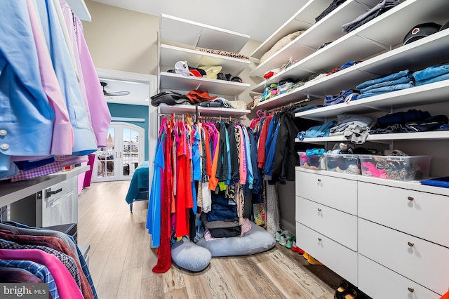 walk in closet featuring light hardwood / wood-style flooring and french doors