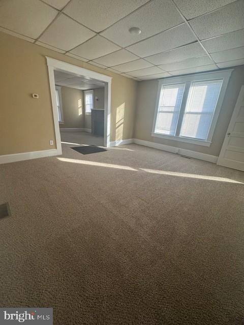 spare room with a drop ceiling and carpet floors