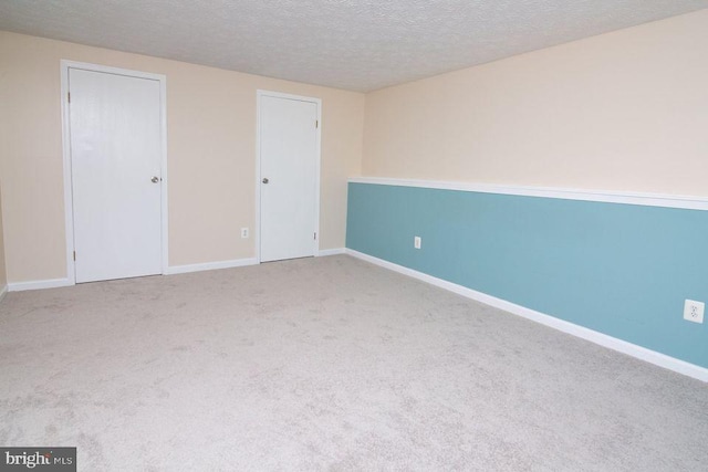 unfurnished room with carpet and a textured ceiling