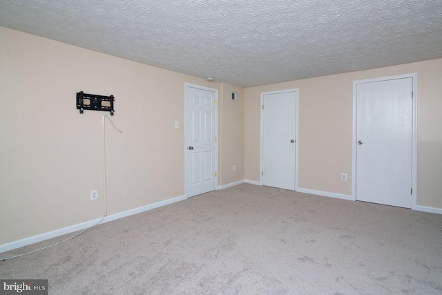 unfurnished bedroom with light carpet and a textured ceiling