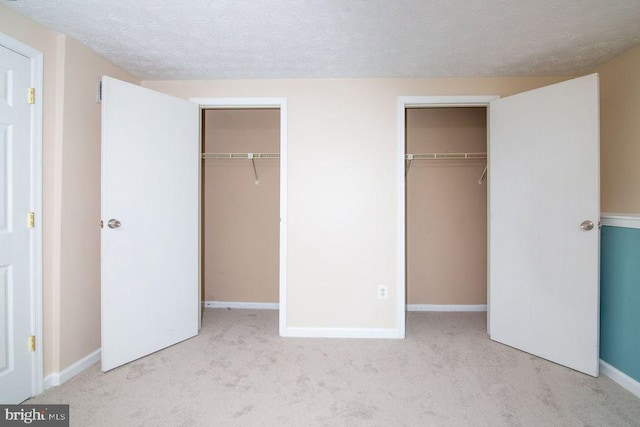 unfurnished bedroom with a textured ceiling and light colored carpet