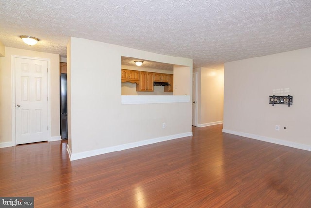 unfurnished living room with a textured ceiling and dark hardwood / wood-style floors