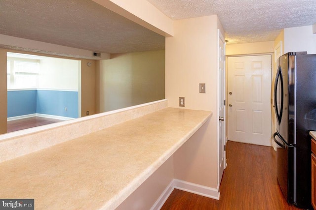 hallway with dark hardwood / wood-style flooring and a textured ceiling