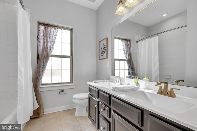 full bathroom with a healthy amount of sunlight, toilet, tile patterned floors, and vanity