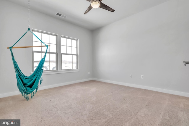 carpeted spare room with ceiling fan