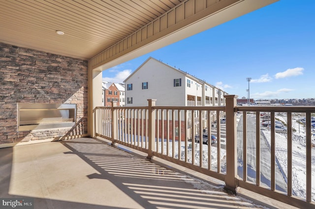 snow covered patio with a balcony