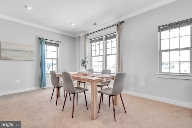 dining area with crown molding and light colored carpet