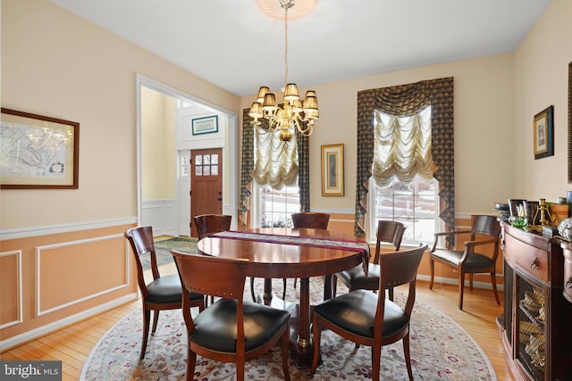 dining space with light hardwood / wood-style floors and a chandelier