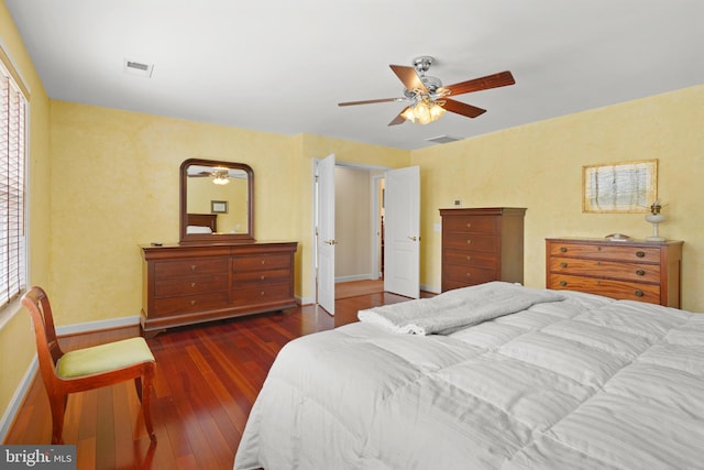 bedroom with ceiling fan, dark wood-type flooring, and multiple windows