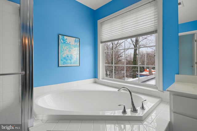 bathroom with tiled bath and vanity