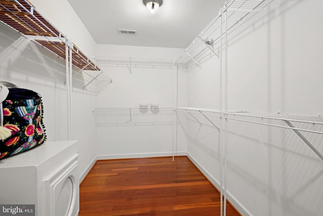 walk in closet with dark hardwood / wood-style flooring