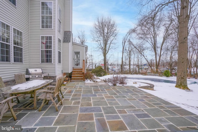 snow covered patio with a grill