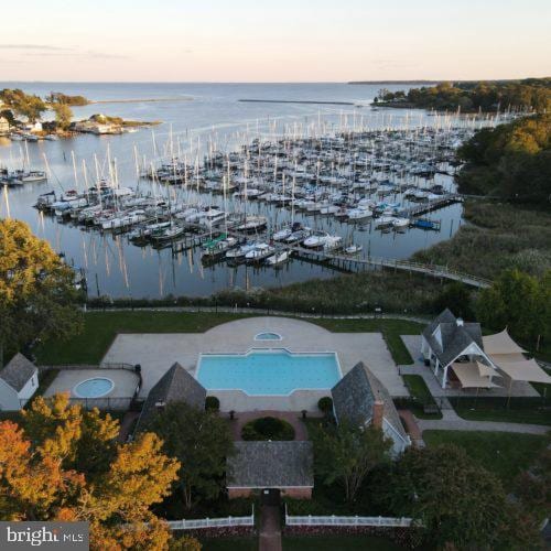 aerial view at dusk featuring a water view