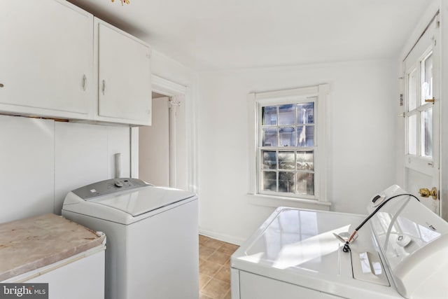 washroom with cabinets and washer and clothes dryer