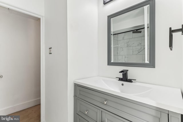 bathroom featuring walk in shower and vanity