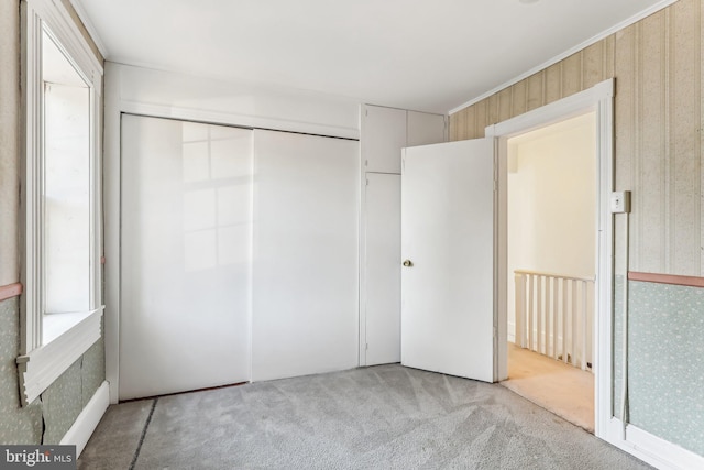 unfurnished bedroom featuring a closet and light carpet