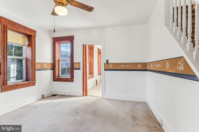 empty room with ceiling fan and light carpet