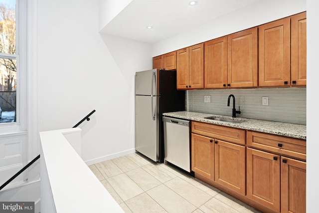 kitchen featuring backsplash, sink, light stone countertops, light tile patterned floors, and stainless steel appliances