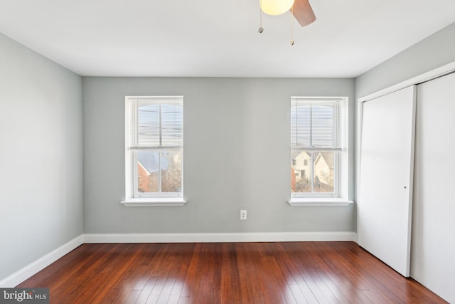 unfurnished bedroom featuring ceiling fan, dark hardwood / wood-style flooring, and a closet