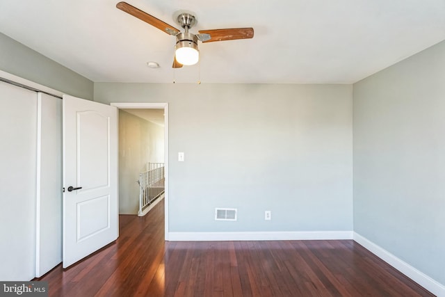 unfurnished bedroom featuring ceiling fan, dark hardwood / wood-style flooring, and a closet